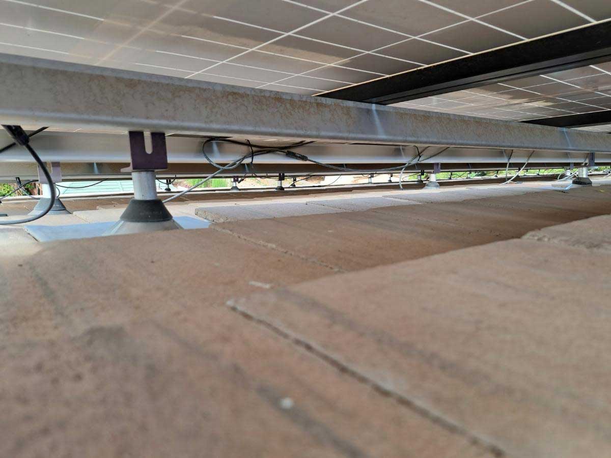 Under-panel view of a rooftop solar installation on a tile roof